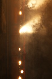 Photo of Professional spotlights and smoke on stage in theatre