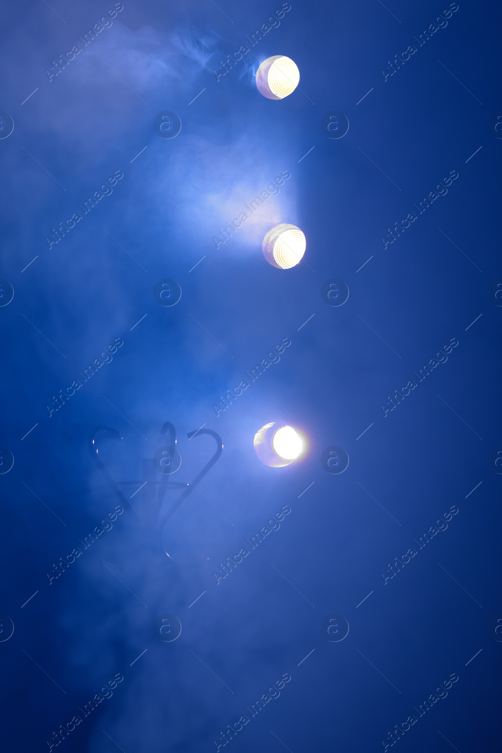 Photo of Professional spotlights and smoke on stage in theatre