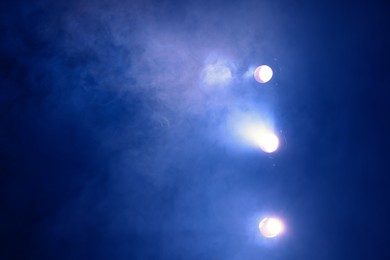 Photo of Professional spotlights and smoke on stage in theatre