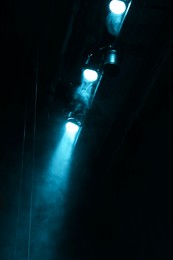 Photo of Professional spotlights and smoke on stage in theatre