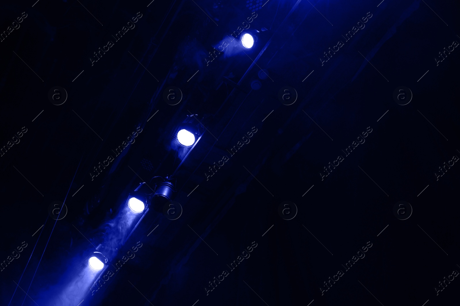 Photo of Professional spotlights and smoke on stage in theatre