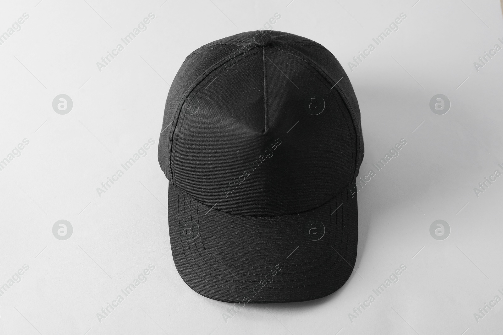 Photo of Stylish black baseball cap on light grey background, above view. Mockup for design