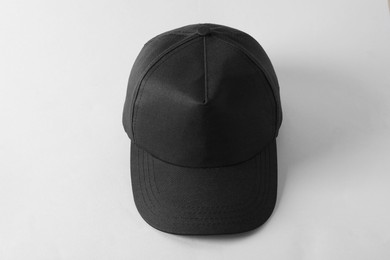 Photo of Stylish black baseball cap on light grey background, above view. Mockup for design