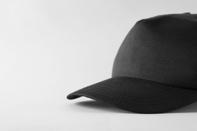 Photo of Stylish black baseball cap on light grey background, closeup. Mockup for design