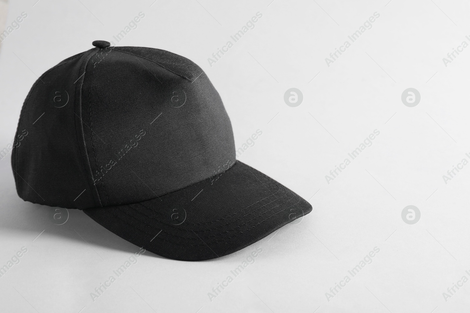 Photo of Stylish black baseball cap on light grey background. Mockup for design