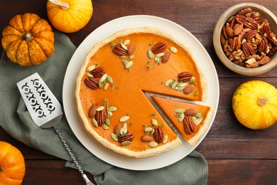 Photo of Tasty homemade pumpkin pie served on wooden table, top view