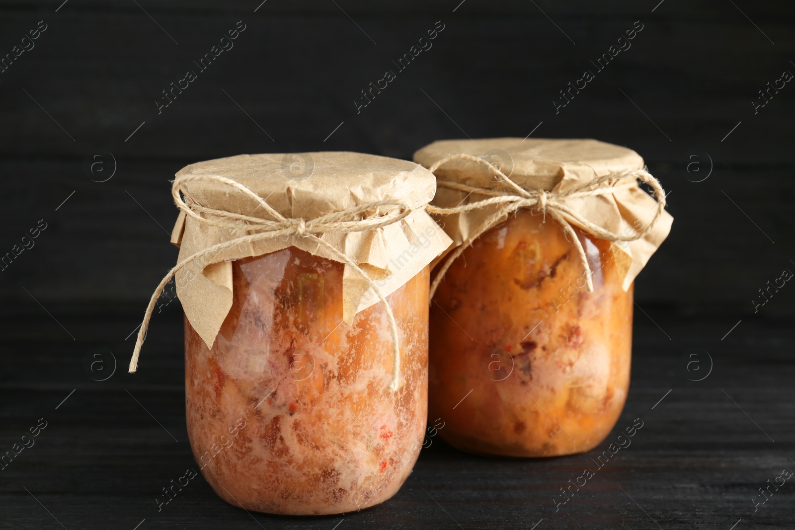 Photo of Canned meat in glass jars on wooden table