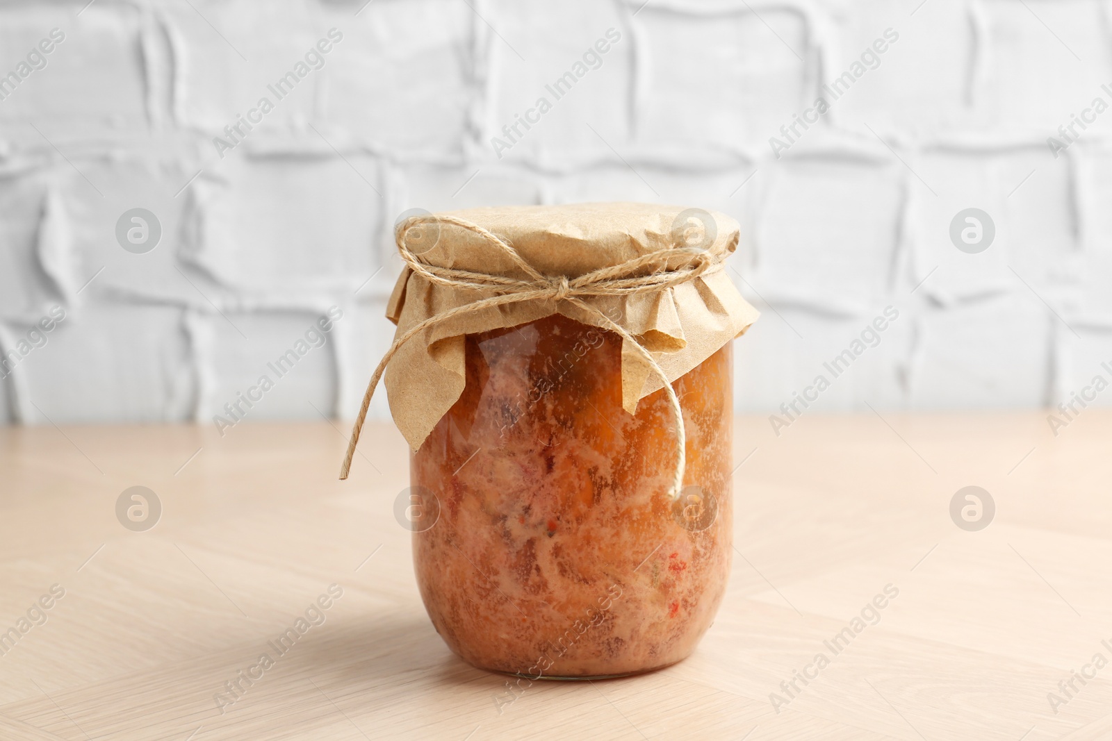 Photo of Canned meat in glass jar on wooden table