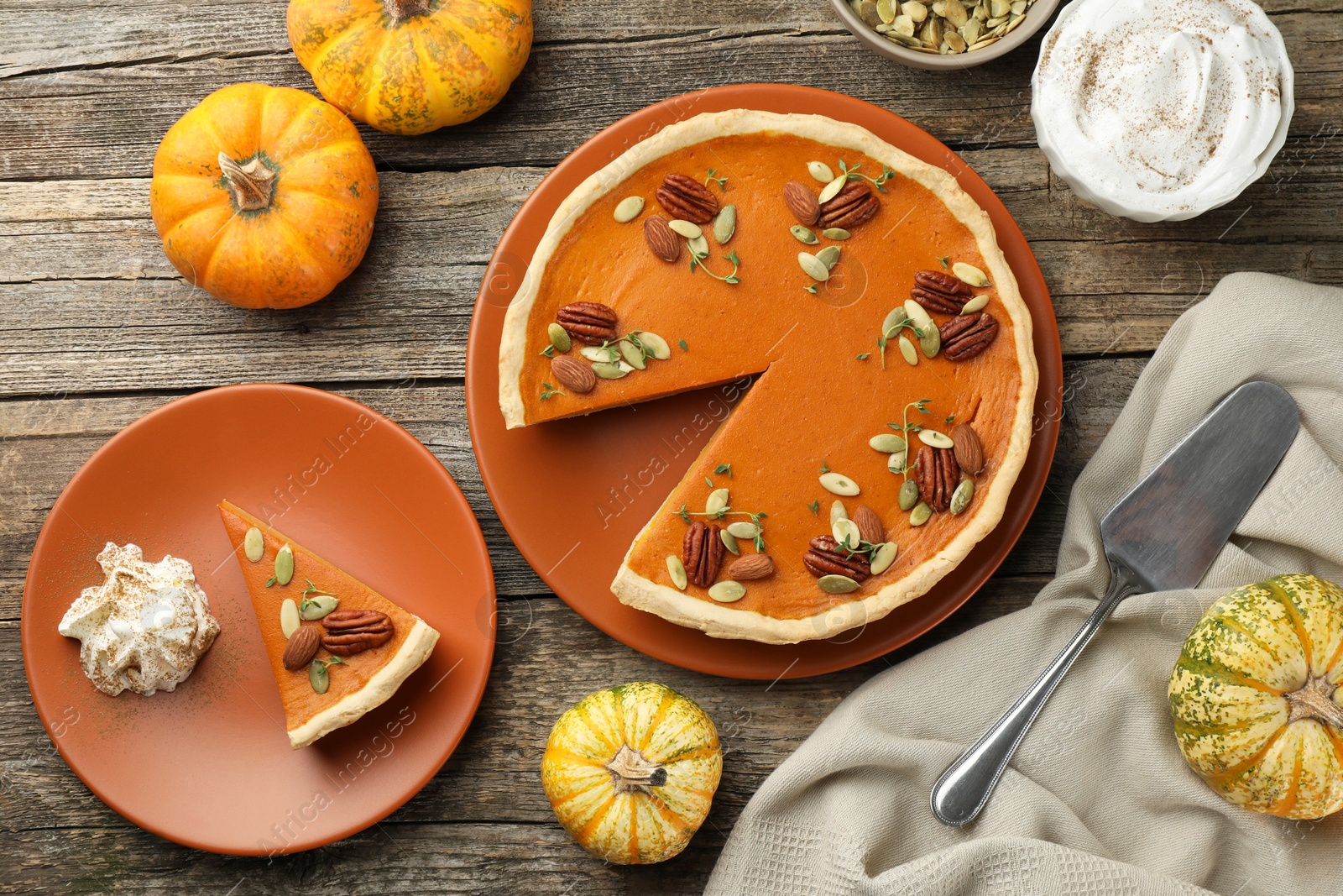 Photo of Tasty homemade pumpkin pie served on wooden table, top view