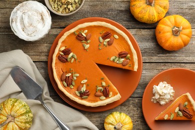 Photo of Tasty homemade pumpkin pie served on wooden table, top view