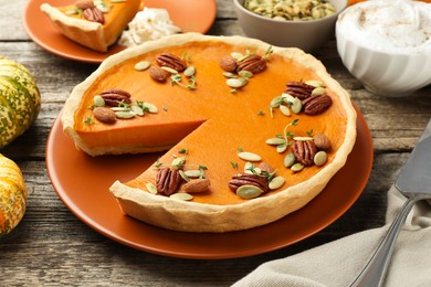 Photo of Tasty homemade pumpkin pie served on wooden table, closeup