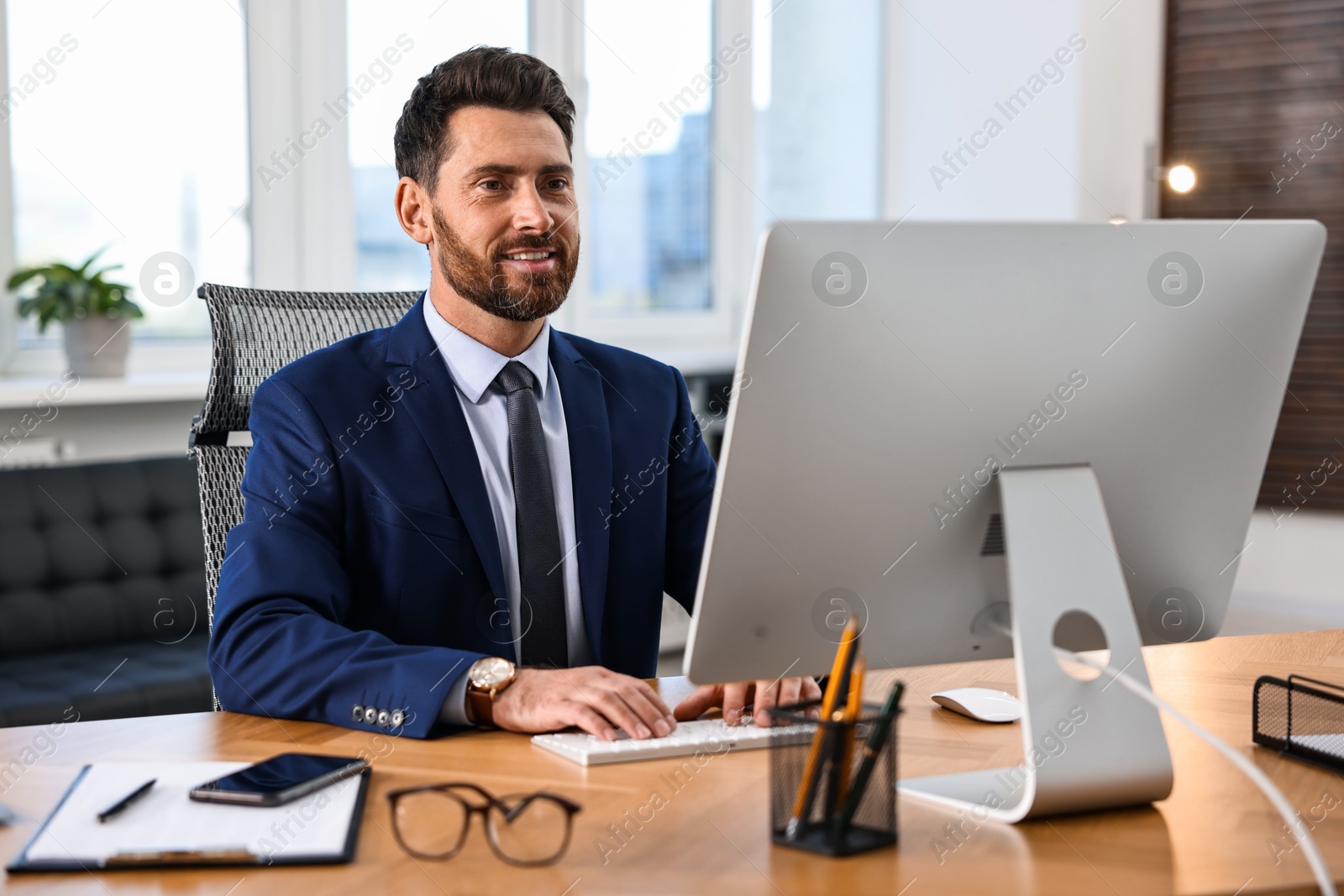 Photo of Man working on computer at table in office