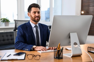 Man working on computer at table in office