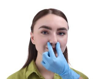 Photo of Doctor checking patient's nose before plastic surgery operation on white background, closeup