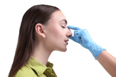 Photo of Doctor checking patient's nose before plastic surgery operation on white background, closeup