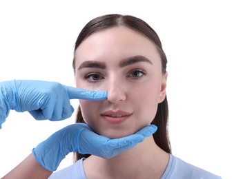 Photo of Doctor checking patient's nose before plastic surgery operation on white background, closeup