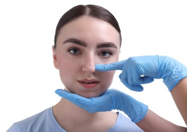 Photo of Doctor checking patient's nose before plastic surgery operation on white background, closeup