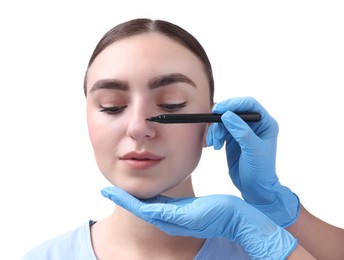 Photo of Doctor drawing marks on patient's nose for plastic surgery operation against white background, closeup