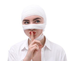 Photo of Woman with nose wrapped in medical bandage after plastic surgery operation making silent gesture on white background