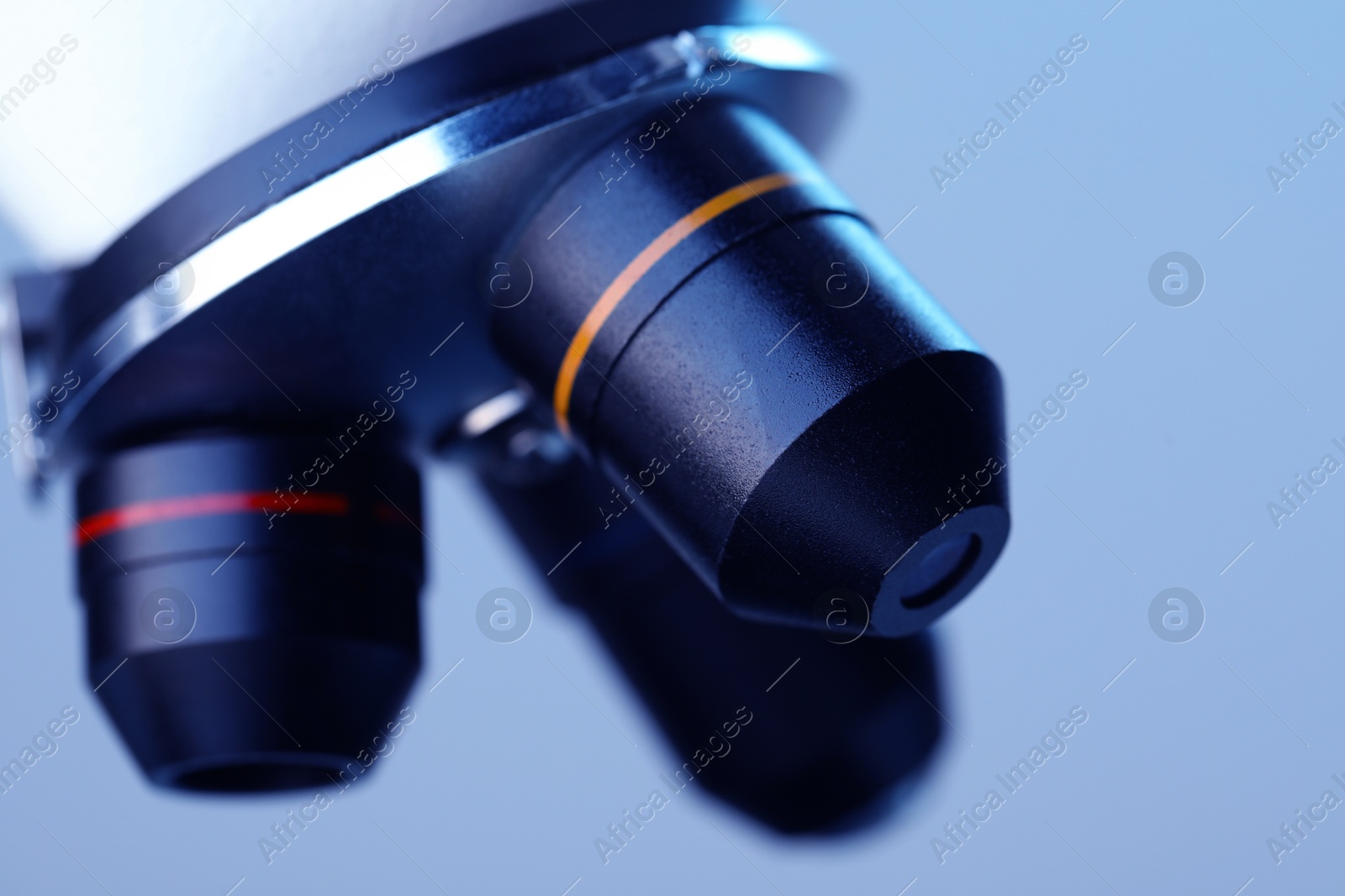 Photo of Science. Modern microscope on light blue background, closeup