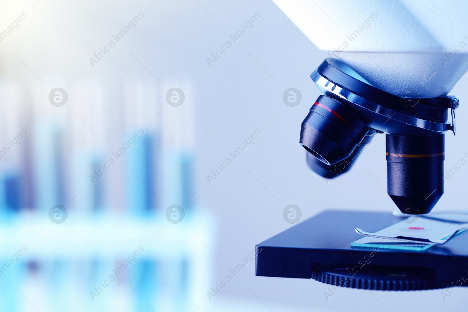 Photo of Science. Microscope with glass slide on blurred background, closeup. Space for text