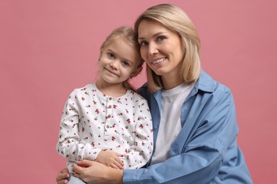 Cute little girl with her mom on pink background. Happy Mother's Day