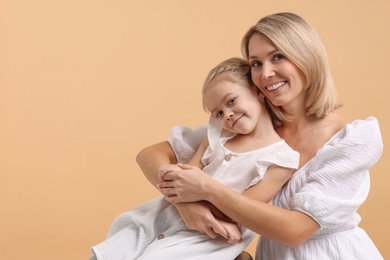 Cute little girl with her mom on beige background, space for text. Happy Mother's Day