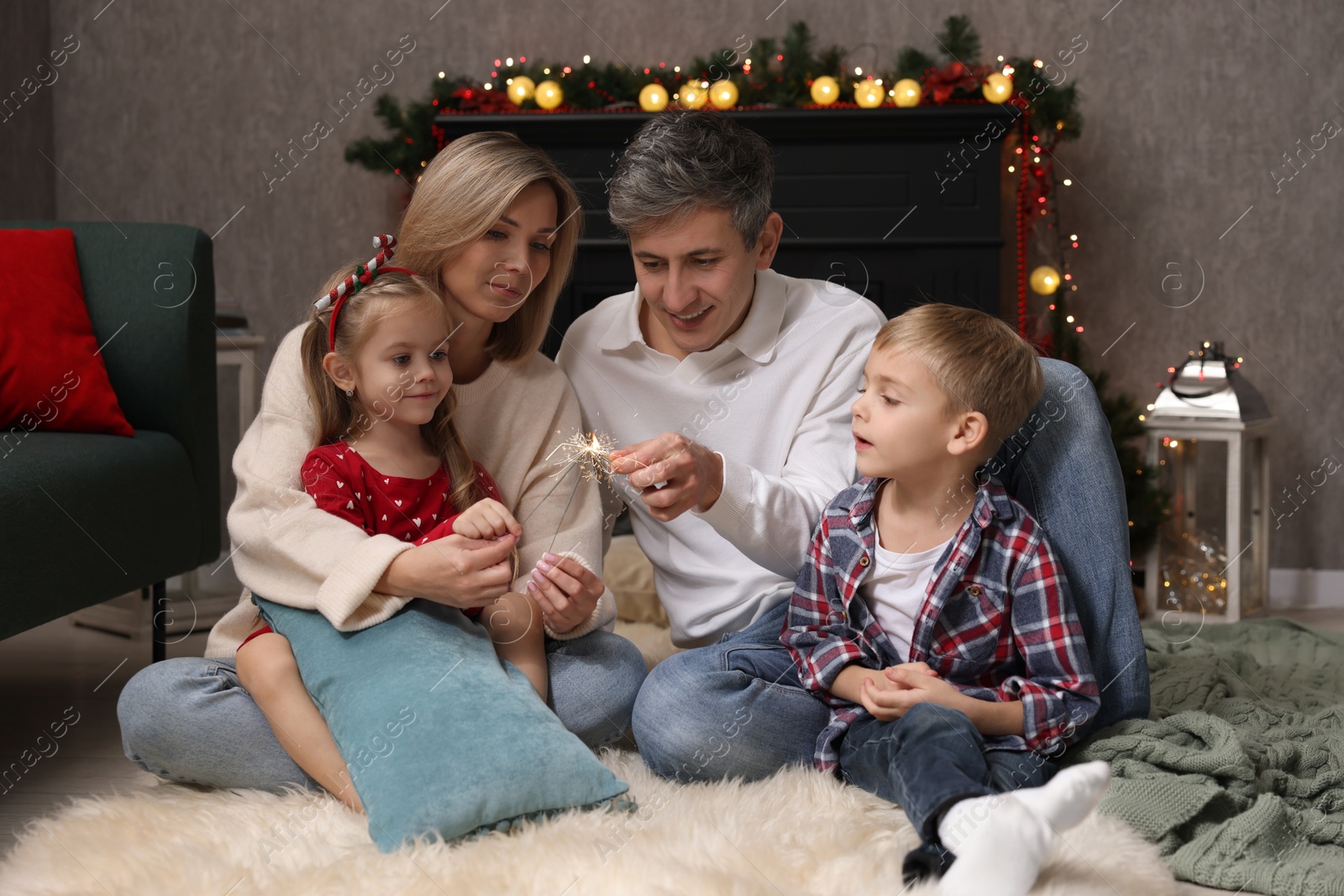 Photo of Lovely family with Christmas sparklers at home