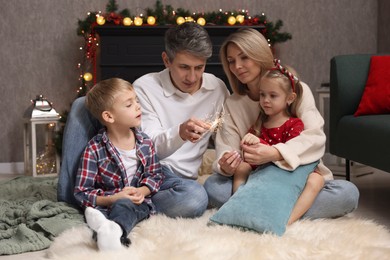 Photo of Lovely family with Christmas sparklers at home