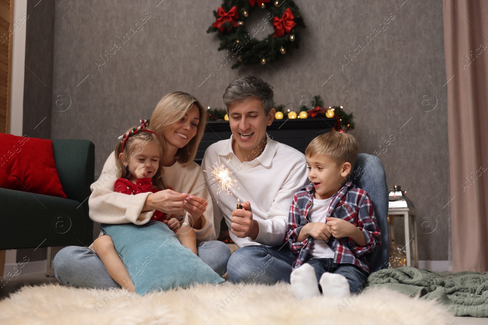 Photo of Lovely family with Christmas sparklers at home