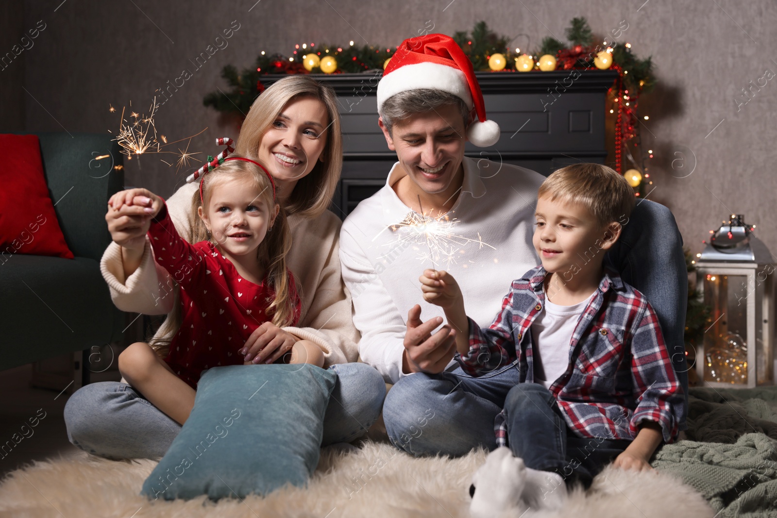 Photo of Lovely family with Christmas sparklers at home