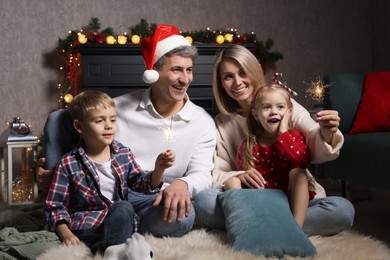 Photo of Lovely family with Christmas sparklers at home