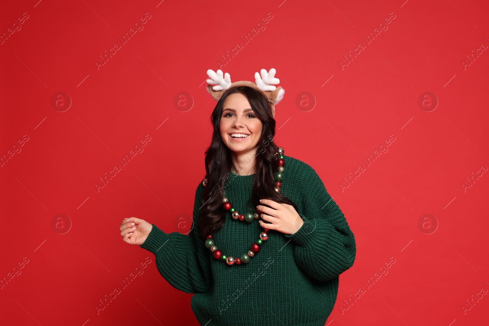 Photo of Beautiful woman with Christmas accessories on red background