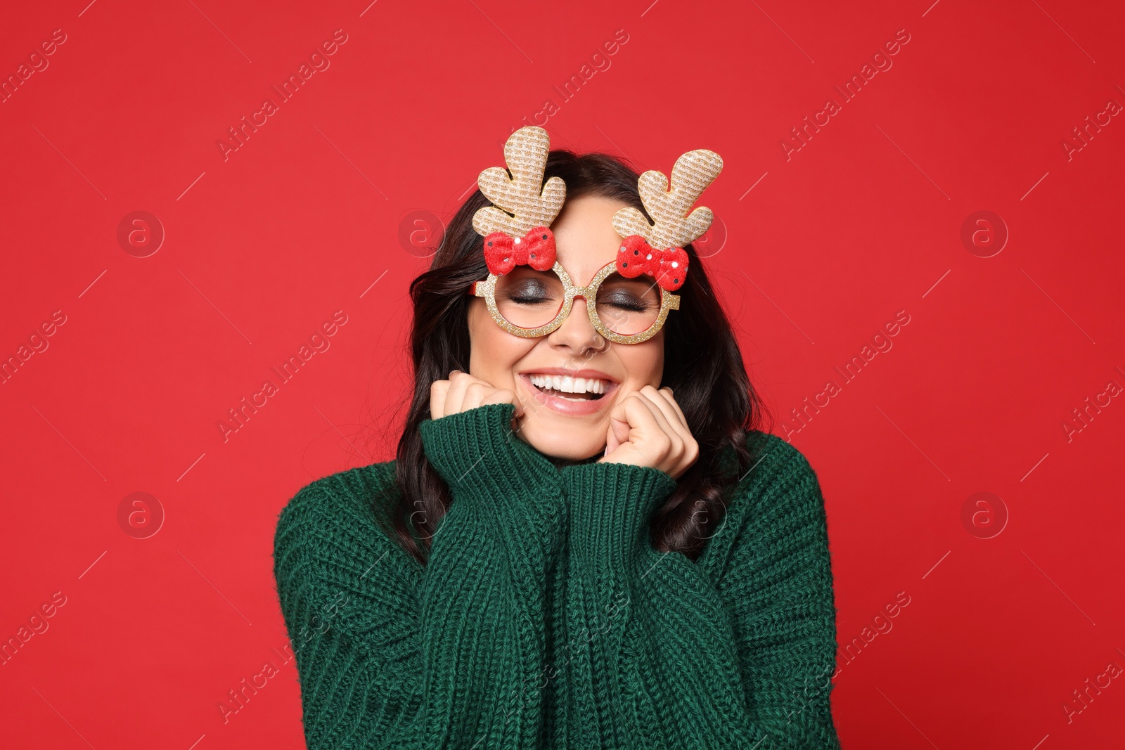 Photo of Happy woman with party glasses on red background. Christmas celebration