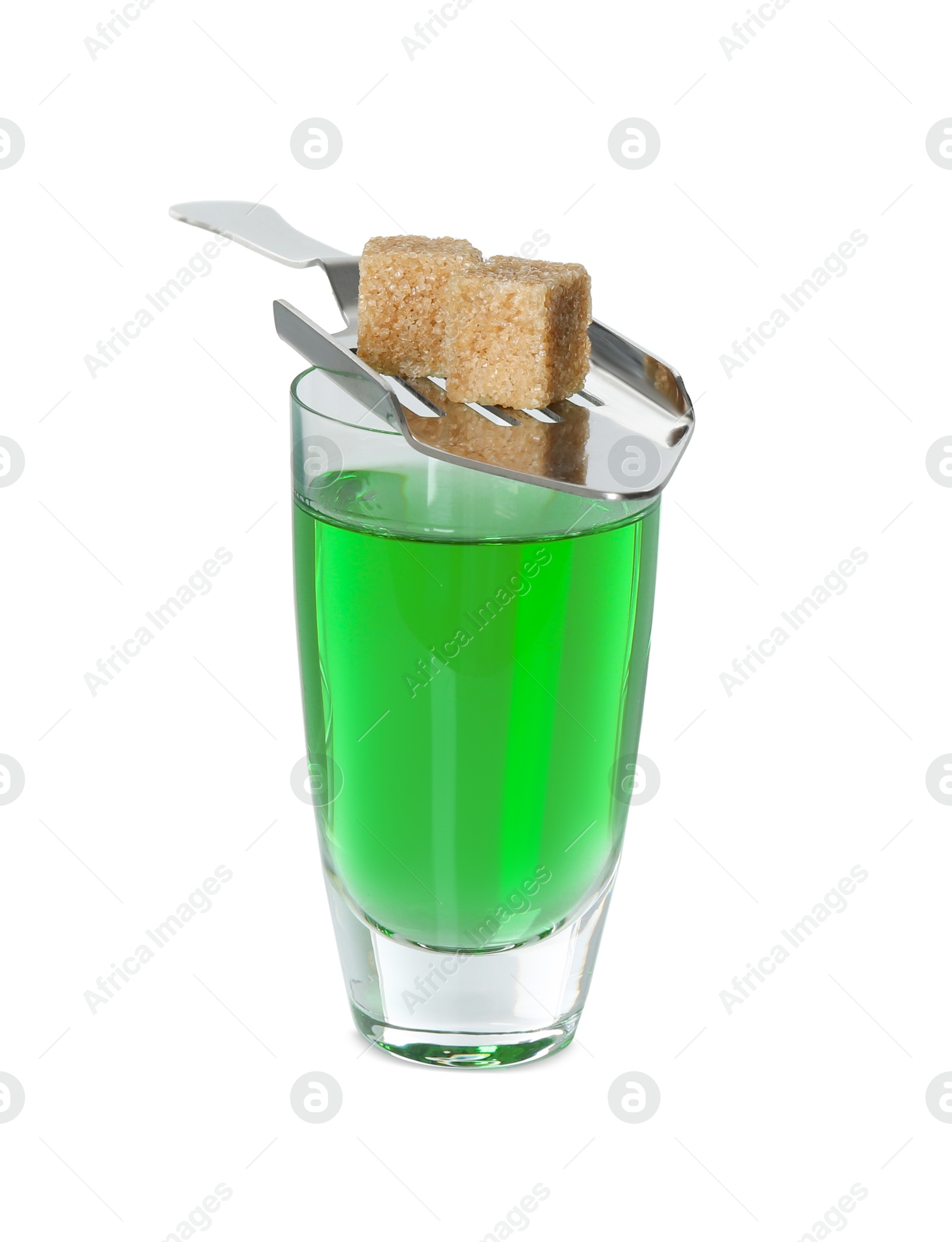 Photo of Absinthe in shot glass, brown sugar cubes and slotted spoon isolated on white