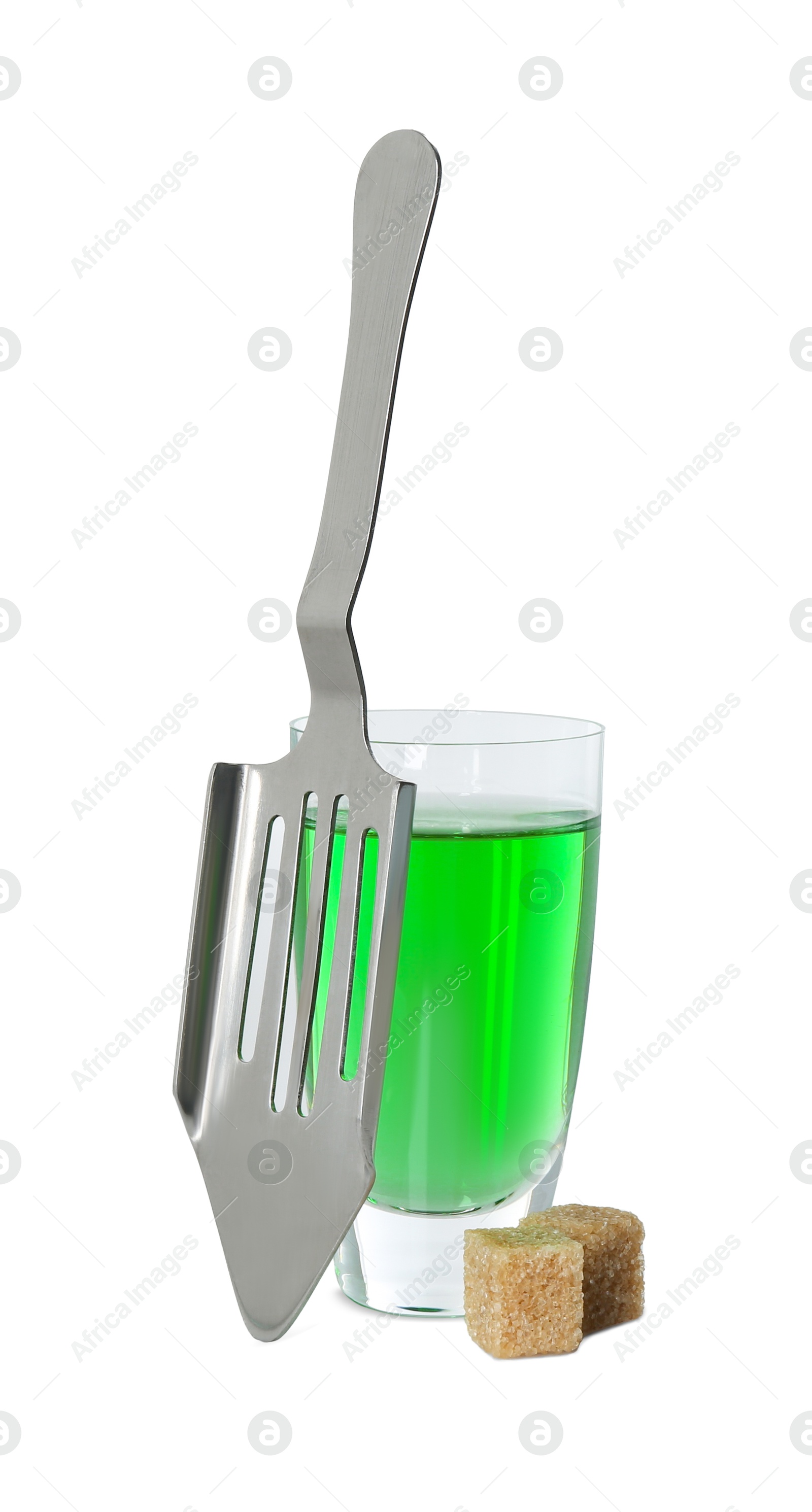 Photo of Absinthe in shot glass, brown sugar cubes and slotted spoon isolated on white