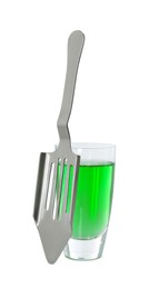 Photo of Absinthe in shot glass and slotted spoon isolated on white