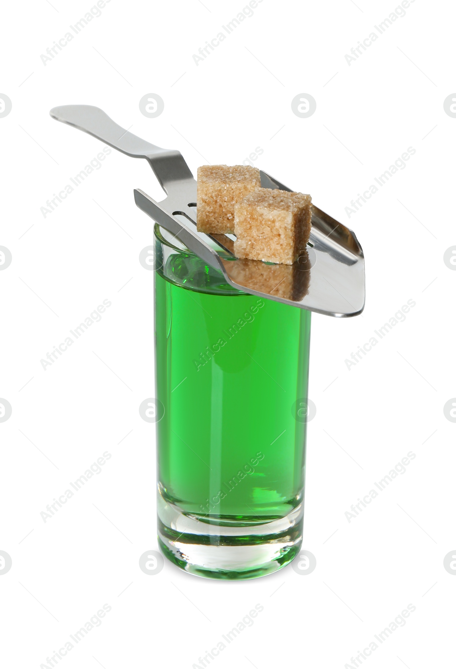 Photo of Absinthe in shot glass, brown sugar cubes and slotted spoon isolated on white