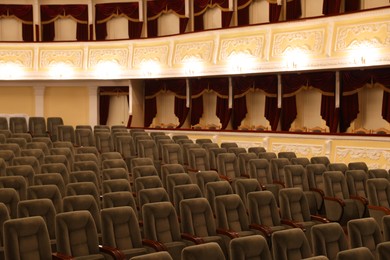 Photo of Rows of gray comfortable seats in theatre