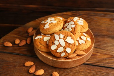 Photo of Tasty cookies with almond flakes and nuts on wooden table