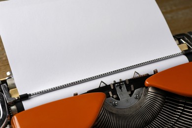 Photo of Vintage typewriter with sheet of paper on table, closeup. Space for text