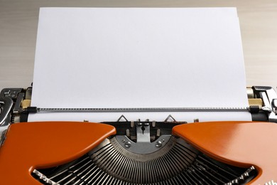 Photo of Vintage typewriter with sheet of paper on table, closeup. Space for text