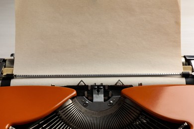 Photo of Vintage typewriter with sheet of paper on table, closeup. Space for text