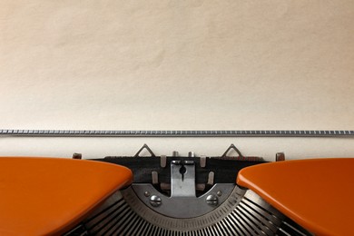 Photo of Vintage typewriter with sheet of paper as background, closeup. Space for text