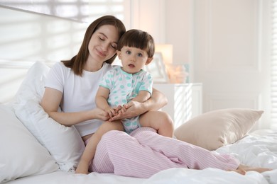 Photo of Happy mother with her little son on bed at home