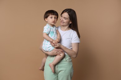 Photo of Family portrait of happy mother with her little son on beige background