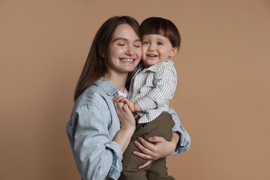 Photo of Family portrait of happy mother with her little son on beige background