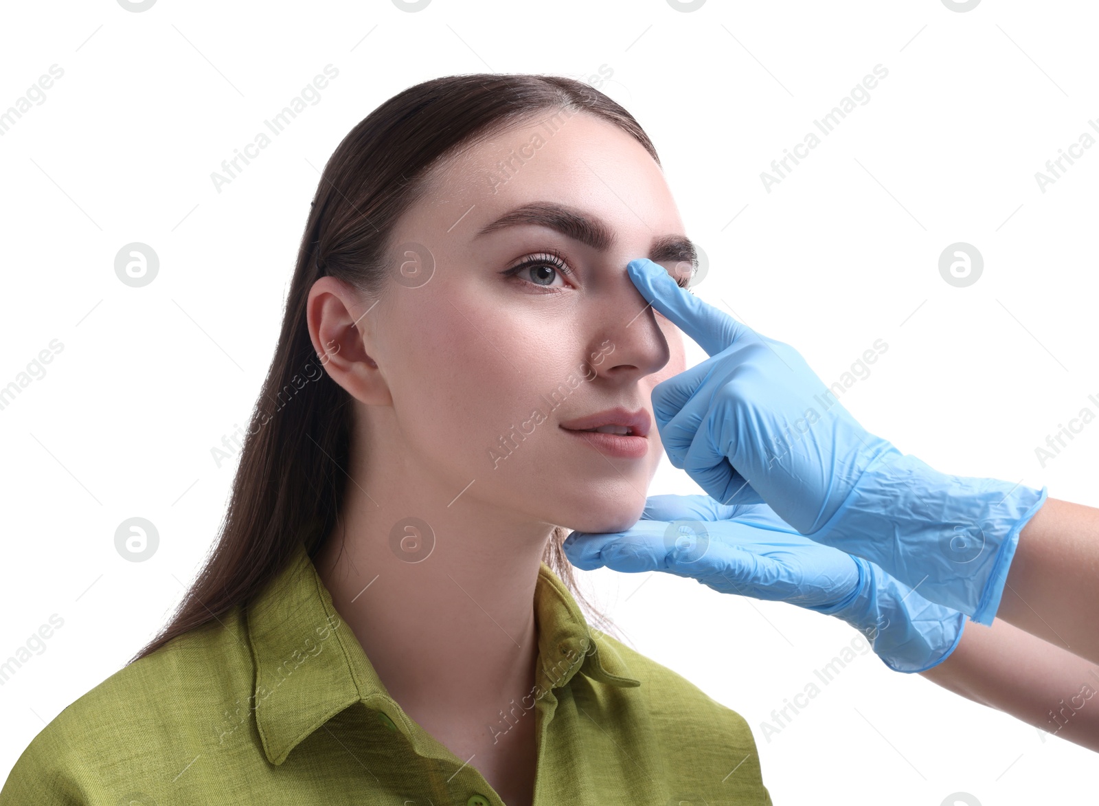 Photo of Doctor checking patient's nose before plastic surgery operation on white background, closeup