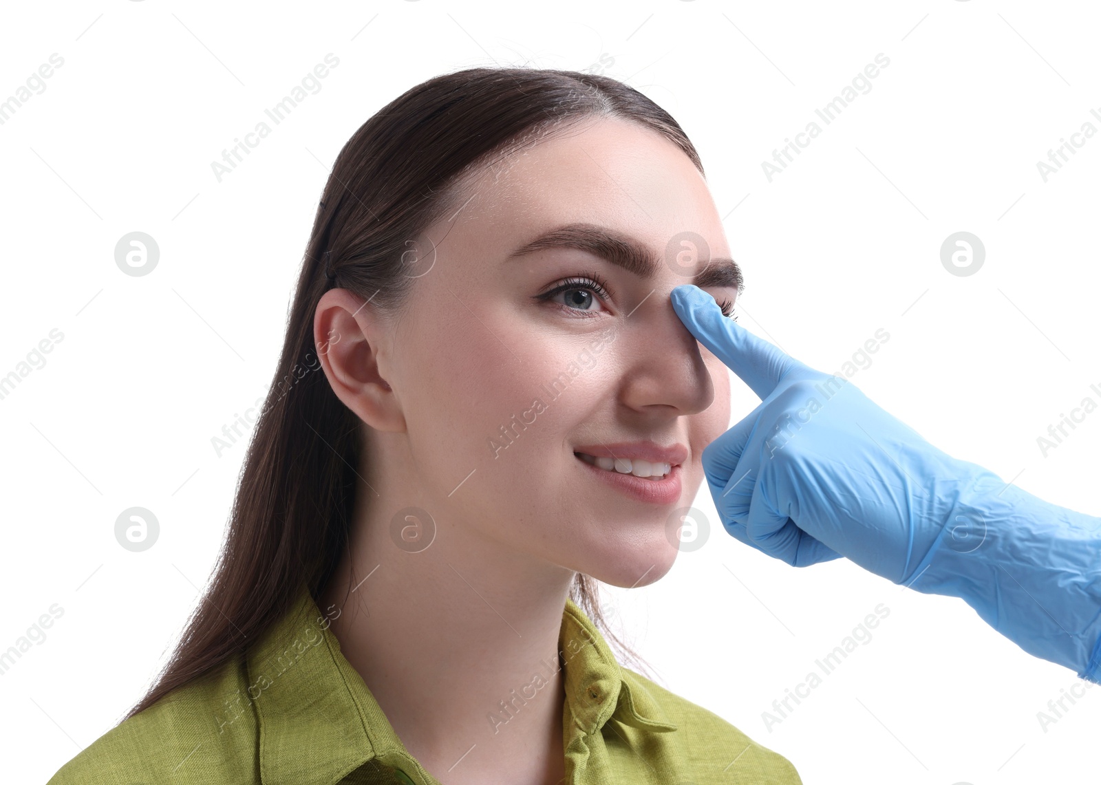 Photo of Doctor checking patient's nose before plastic surgery operation on white background, closeup