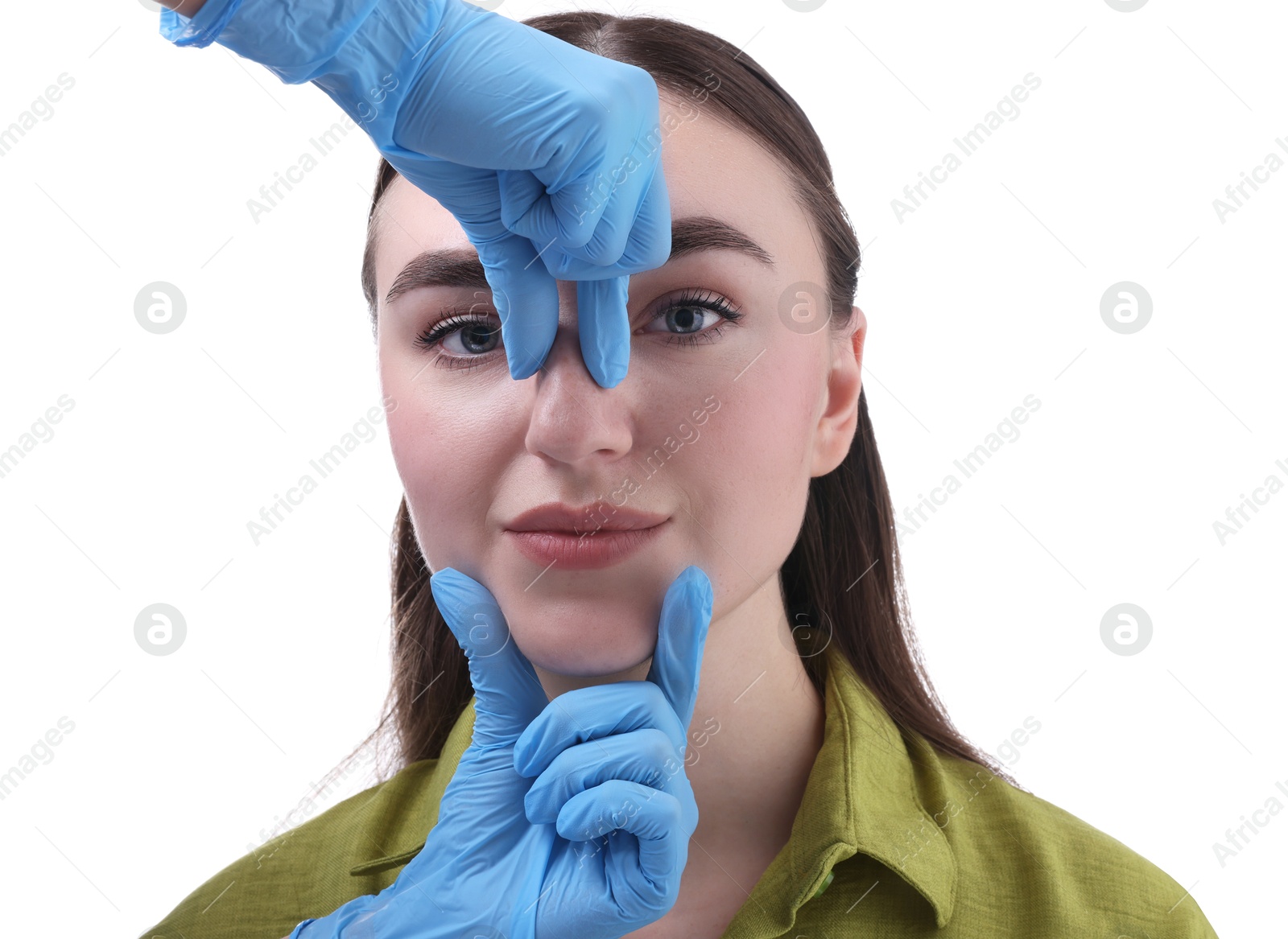 Photo of Doctor checking patient's nose before plastic surgery operation on white background, closeup